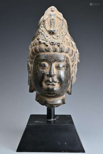 A Chinese carved stone head of Guanyin on metal stand,