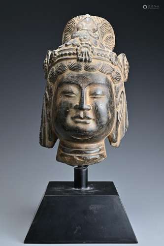 A Chinese carved stone head of Guanyin on metal stand,