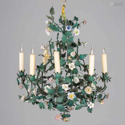 A chandelier made of metal and decorated with flowers made o...