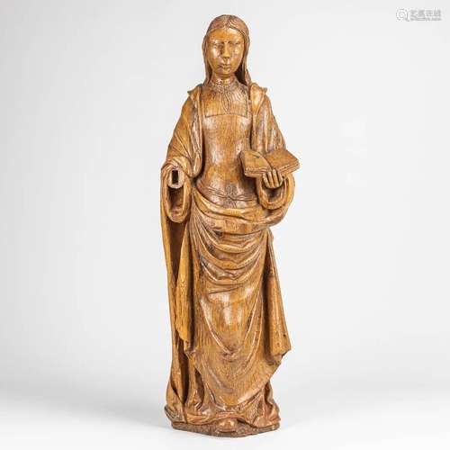 An antique wood sculptured statue of a lady with a book. Mad...