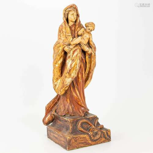 An antique wood sculpture of Madonna with a child, standing ...