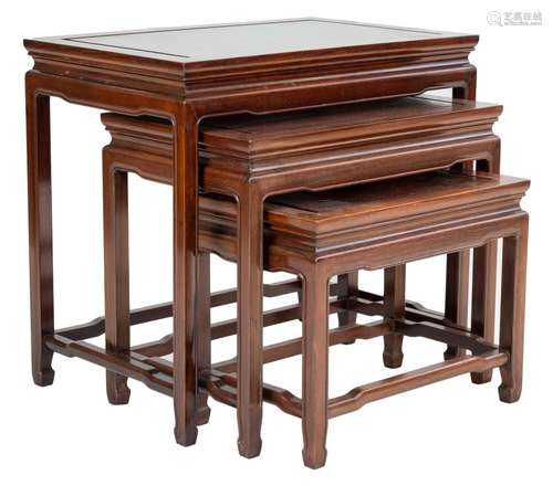 A Chinese hardwood nest of three side tables with