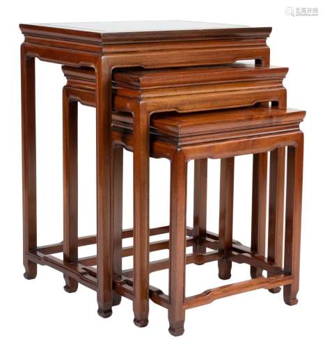 A Chinese hardwood nest of three side tables with