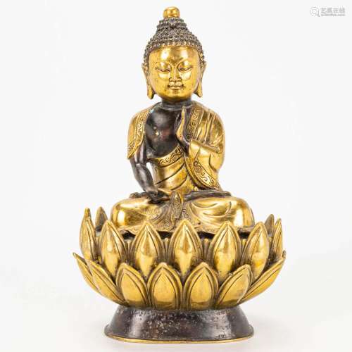 A Buddha on a lotus flower made of bronze.