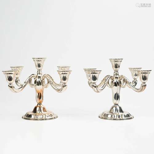 A pair of candelabra made of silver and marked 0,835. Made i...