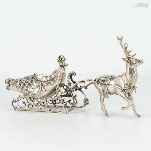 A reindeer with a sled, made of silver and marked