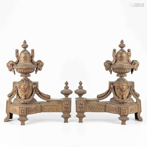 A pair of bronze fireplace andiron decorated with ram's...