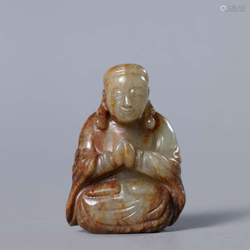 A Carved Russet and White Jade Buddha Statue