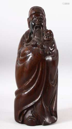 A CHINESE CARVED HARDWOOD FIGURE OF A SAGE AND CHILD - the l...