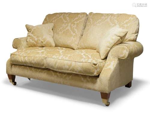 A cream upholstered three piece suite, comprising two seater...