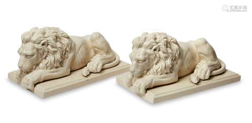 A pair of glazed pottery models of reclining lions, by L&...