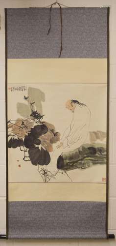 A CHINESE SCROLL PAINTING OF A STYLISED FIGURE amongst flora...