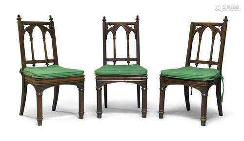 A set of three Victorian Gothic Revival oak side chairs, the...