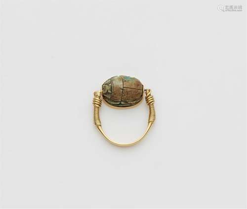 An 18k gold twisting ring with an ancient Egyptian scarab am...