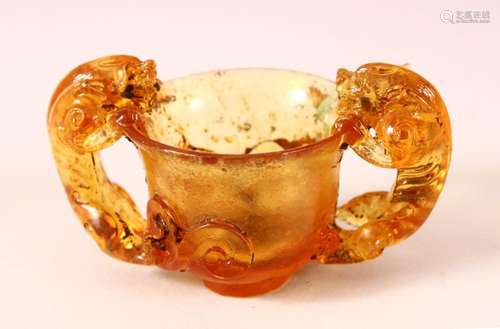 A CHINESE PEKING AMBER GLASS TWIN HANDLE CUP, with twin beas...