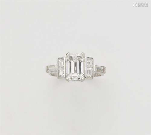 A platinum diamond ring with an emerald-cut diamond solitair...