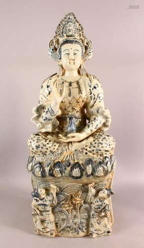 A LARGE CHINESE PORCELAIN FIGURE OF GUANYIN - Seated upon st...