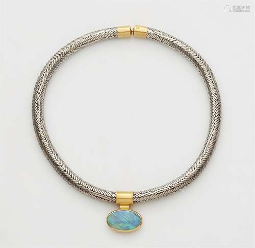 An Indian woven silver necklace with a gold and opal pendant