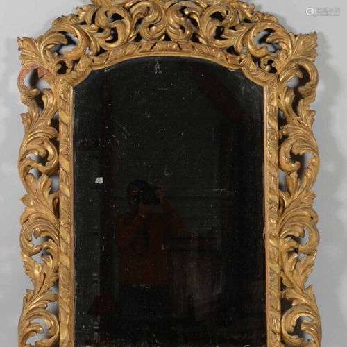 Miroir en bois doré sculpté à décor de larges feuillages et ...