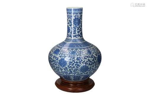 A blue and white porcelain bottle vase on carved wooden base...