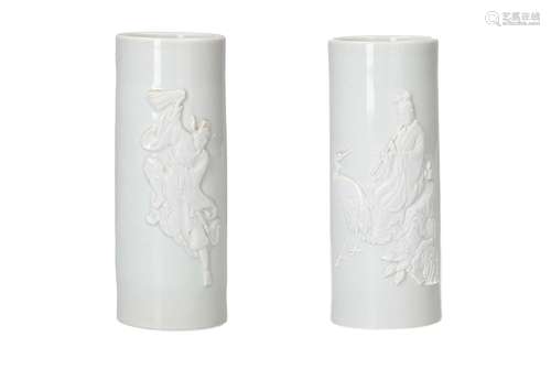 A pair of blanc de Chine porcelain brush pots with relief de...