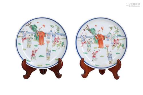 A pair of polychrome porcelain dishes on wooden stands, deco...