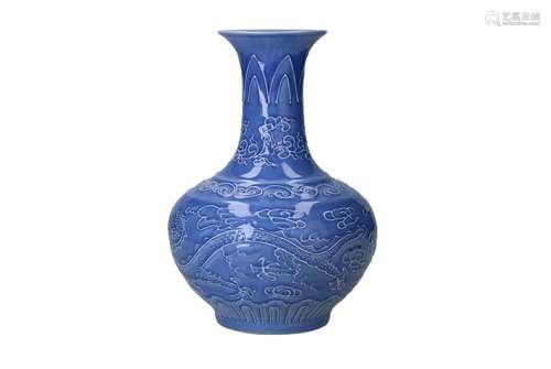 A blue glazed porcelain vase with white relief decor of drag...