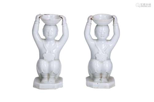 A pair of blanc de Chine porcelain candle holders in the sha...