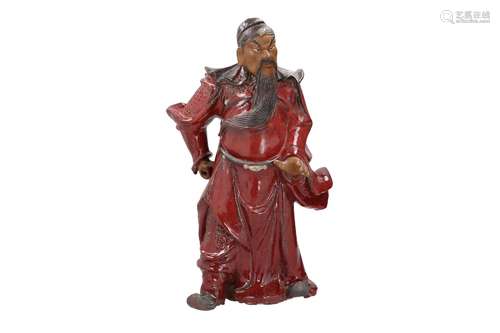 A red glazed earthenware sculpture depicting an angry figure...