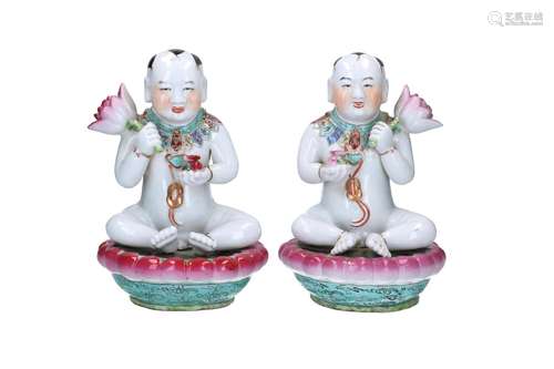 A pair of polychrome porcelain sculptures, depicting boys on...