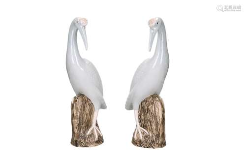 A pair of porcelain sculptures, depicting cranes. Each bird ...