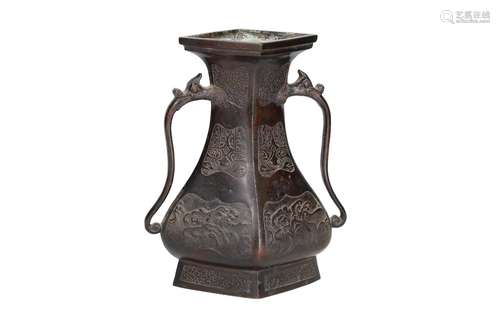 A bronze vase with two handles in the shape of animal heads,...