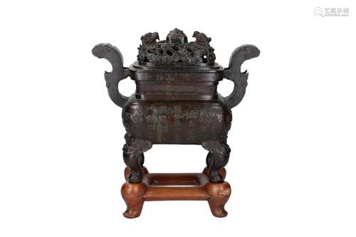 A bronze censer with two handles and cover on wooden stand, ...