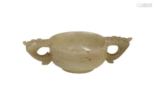 A carved jade bowl with two handles in the shape of dragon h...