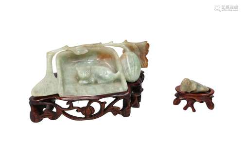 A carved jade and russet jade sculpture on wooden base, depi...