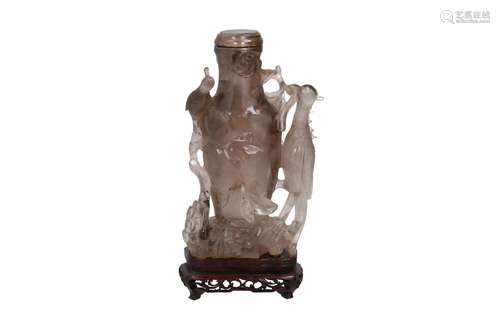 A carved smoky quartz lidded vase on wooden base, depicting ...