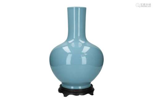 A clair de lune glazed porcelain vase on wooden stand. Marke...