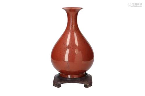 A copper red glazed porcelain vase on wooden stand. Unmarked...