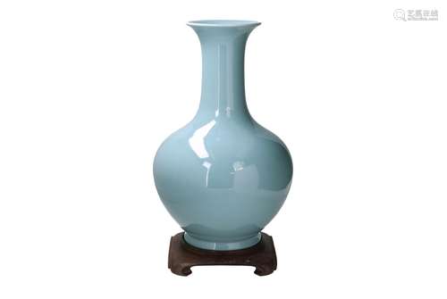 A clair de lune glazed porcelain vase on wooden stand. Unmar...