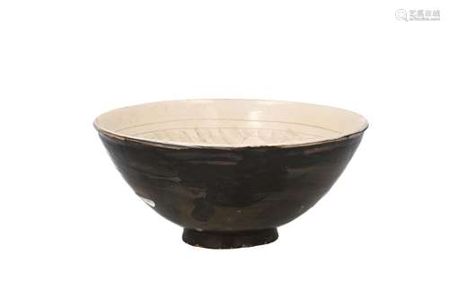 A Cizhou stoneware bowl with carved decor of peonies on a wh...