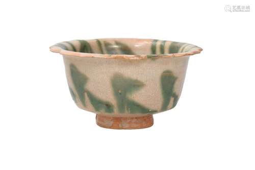 A cream glazed pottery bowl with green splash decor and scal...