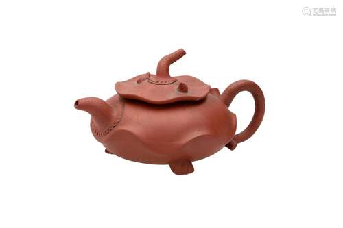 A Yixing teapot in the shape of a fruit. The three legs in t...