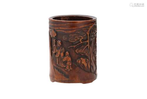 A cylindrical bamboo brush pot with carved decor of a schola...