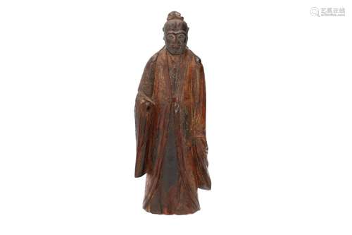 A wooden sculpture of a standing scholar. China, Ming. H. 24...