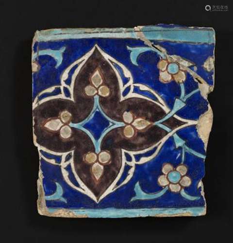 A large Timurid cuerda seca pottery tile decorated in blue, ...