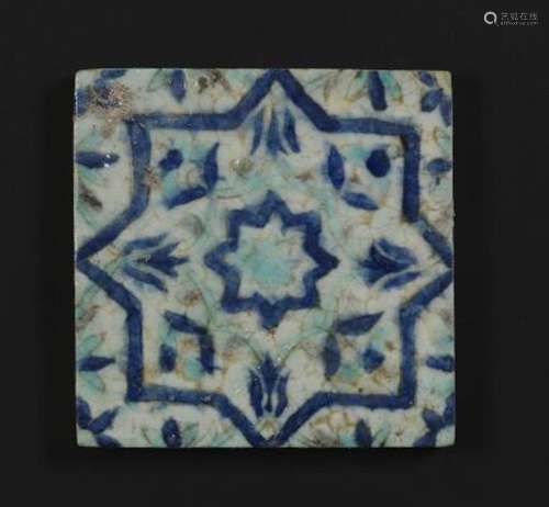 A pottery tile decorated in blue and turquoise with stars an...