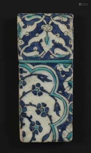 A pottery tile decorated in blue and turquoise with flowers