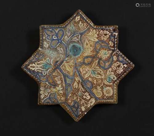 A Kashan star shaped pottery tile decorated in lustre, blue ...