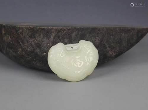A FINELY CARVED HETIAN GREENISH WHITE JADE PENDANT