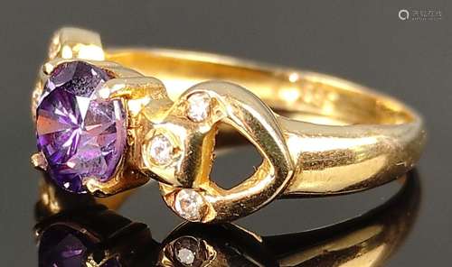 Ring with faceted purple gemstone flanked by three…